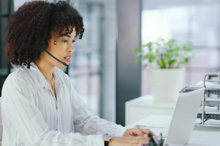 woman at computer wearing headset